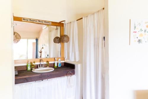 ein Bad mit einem Waschbecken und einem Spiegel in der Unterkunft LAGOON SPECIAL Suite: Bikes & Kayaks! in Bacalar