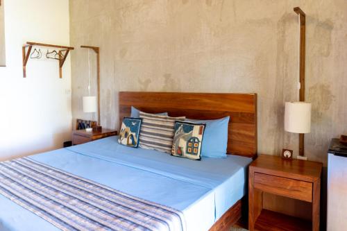 a bedroom with a blue bed with two pillows at LAGOON SPECIAL Suite: Bikes & Kayaks! in Bacalar