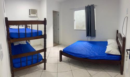 a bedroom with two bunk beds and a window at SUITEs E FLATs MONTE ALTO ARRAIAL DO CABO in Arraial do Cabo