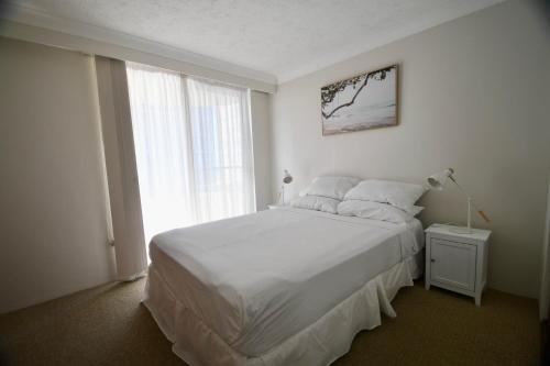 Un dormitorio blanco con una cama grande y una ventana. en Sandbar Unit 203, en Forster
