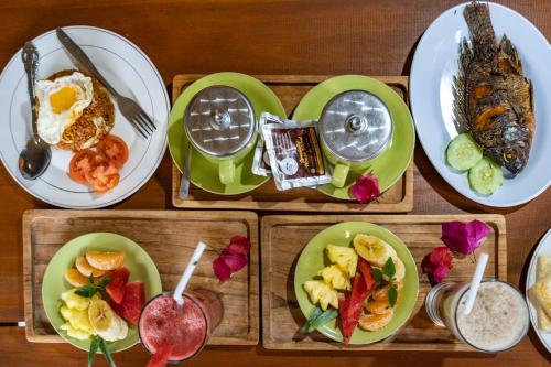 a table topped with plates of food with breakfast foods at KINTAMANI Paradise Villa in Kintamani