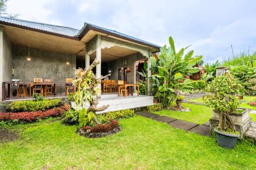a house with a porch and a grass yard at KINTAMANI Paradise Villa in Kintamani