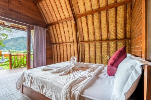 a bed in a room with a wooden wall at KINTAMANI Paradise Villa in Kintamani