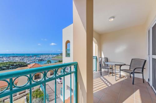 a balcony with a table and chairs and a view of the ocean at Shingley Beach Resort - Whitsundays in Airlie Beach