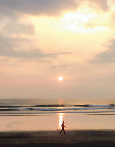 a person walking on the beach at sunset at Cocorico Beach Resort in Dapoli