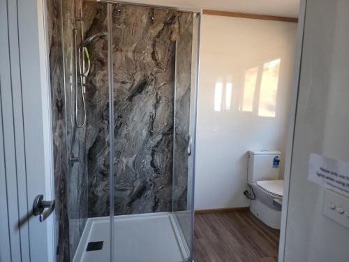 a bathroom with a glass shower with a toilet at Mount Rumney Escapes Seaview House 1 - Possum House in Mount Rumney