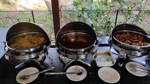 two pots and pans on a stove with food at Cocorico Beach Resort in Dapoli