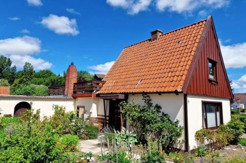 une petite maison blanche avec un toit rouge dans l'établissement "Ohuus" Ferienhaus mit Garten, à Büsum