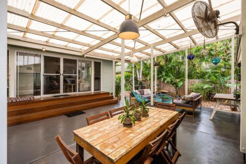 a patio with a wooden table and chairs and a ceiling at Sea Dip at Iluka in Iluka