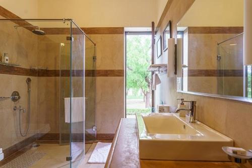 une salle de bain avec un lavabo et une douche en verre dans l'établissement amã Stays & Trails Abhay Villa Bisalpur, Jodhpur, à Jodhpur