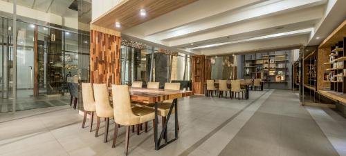 a dining room with a wooden table and chairs at Grande Valore Hotel Cikarang in Cikarang