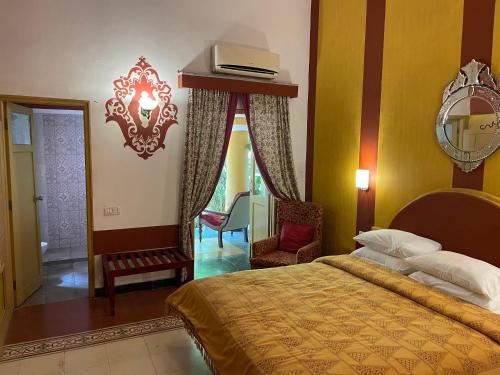 a bedroom with a bed and a chair in it at Casa Anjuna in Anjuna