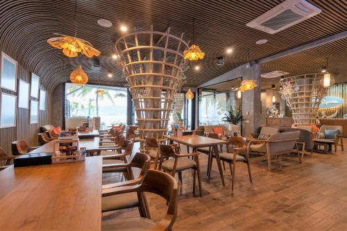 a restaurant with tables and chairs and a chandelier at Patong Signature Boutique Hotel in Patong Beach