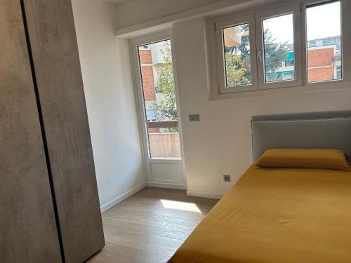 a bedroom with a bed and two windows at Apartment Regina Luxury Lugano in Lugano