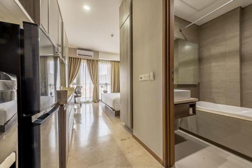 a bathroom with a tub and a sink and a toilet at Grande Valore Hotel Cikarang in Cikarang
