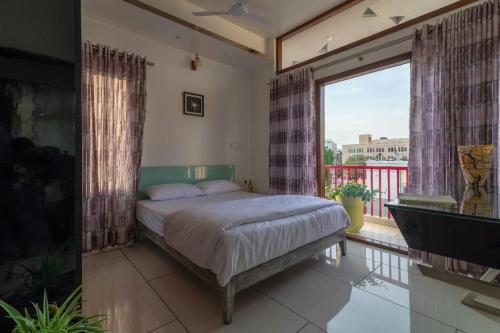 1 dormitorio con cama y ventana grande en Glass Apartment, en Bangalore