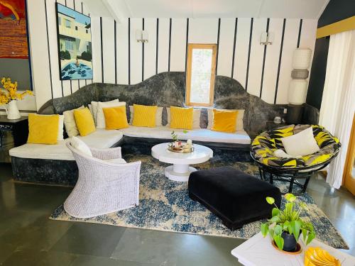 a living room with a couch with yellow pillows at Casa Anjuna in Anjuna