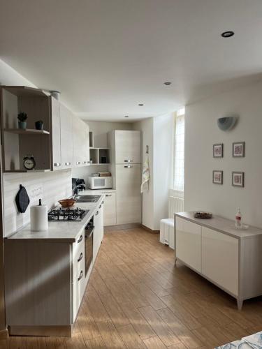 a kitchen with white cabinets and a stove top oven at La Maison di Gabriella e Alfredo in Edolo