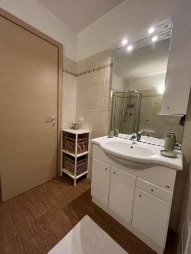 a bathroom with a white sink and a mirror at La Maison di Gabriella e Alfredo in Edolo