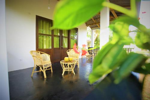 a porch with chairs and a table with fruit on it at Rekawa Lagoon Resort in Tangalle