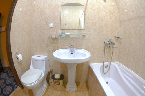 y baño con lavabo, aseo y espejo. en Minorai Kalon Boutique Hotel, en Bukhara