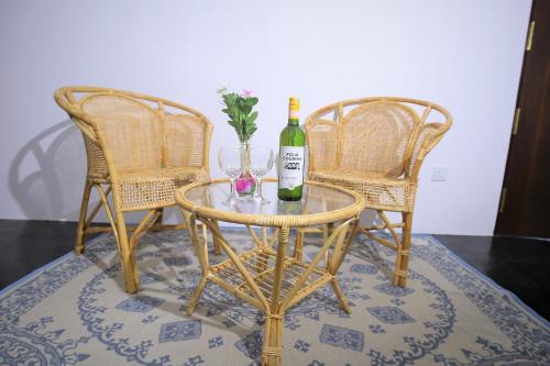 a table with a bottle of wine and two chairs at Rekawa Lagoon Resort in Tangalle