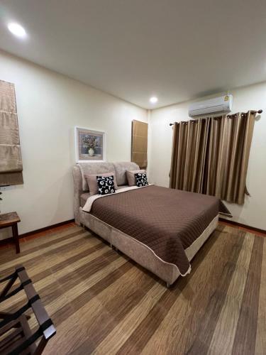 a bedroom with a large bed and a couch at New Home Yบ้านเดี่ยวสร้างใหม่ ใกล้ทะเล ใจกลางเมืองระยอง in Ban Chak Phai