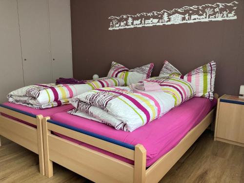 a bed with colorful sheets and pillows on it at Chalet Aloa in Adelboden
