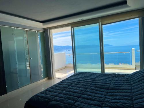 a bedroom with a bed with a view of the ocean at Conchas chinas sunset view in Puerto Vallarta