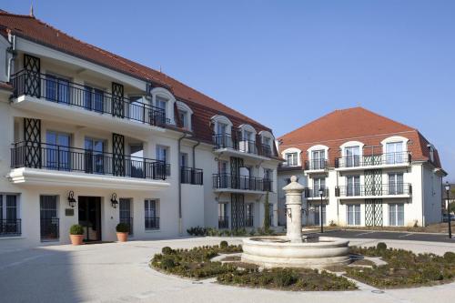 a building with a fountain in the middle of a courtyard at Medicis Home Beaune in Beaune