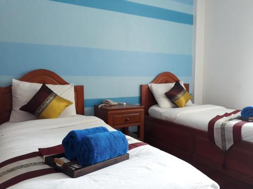- une chambre avec 2 lits et des serviettes dans l'établissement Wiriya House, à Chiang Mai