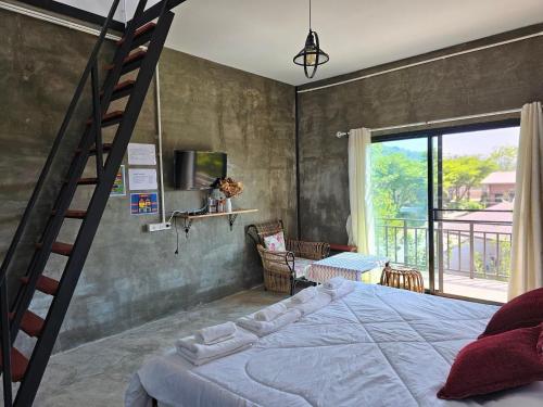 a bedroom with a large bed and a ladder at ไร่ปาริชาติ in Ban Khanong Phra Tai