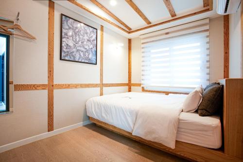 Schlafzimmer mit einem Bett und einem Fenster in der Unterkunft Geonmaek Stay in Mokpo