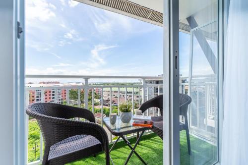 a balcony with two chairs and a table with a view at 732 Express Condotel, 3 Minutes to Airport, FAST WI-FI, Free Netflix in Pusok