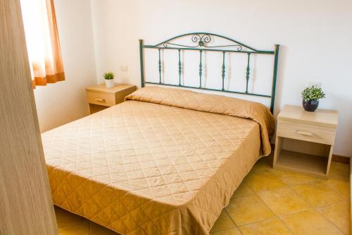 a bedroom with a bed and two night stands at Case Gialle in San Teodoro