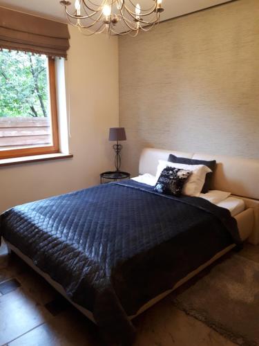 Un dormitorio con una cama grande y una lámpara de araña. en Remigija Studio Home en Jonava