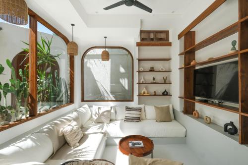 a living room with a white couch and a tv at The Arki Villa in Canggu
