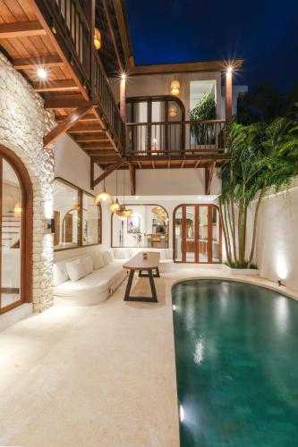 a house with a swimming pool in a living room at The Arki Villa in Canggu