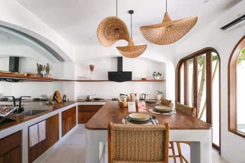 eine Küche mit einem Tisch, Stühlen und einer Arbeitsplatte in der Unterkunft The Arki Villa in Canggu