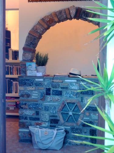 a brick fireplace in a room with a book shelf at Kallichoron Art Boutique Hotel in Astypalaia Town