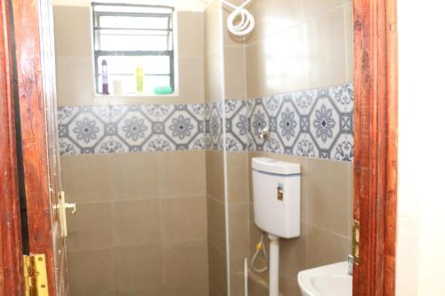 a small bathroom with a toilet and a sink at Zanale Stays Furnished Apartment? in Nairobi