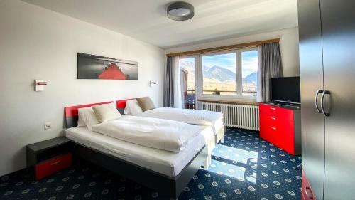 a hotel room with two beds and a window at Cresta Sedrun in Sedrun