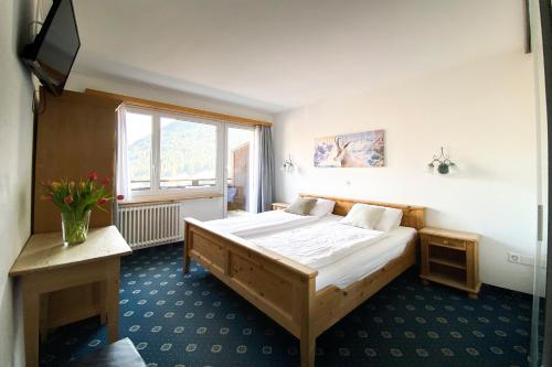 a bedroom with a large bed and a window at Hotel Cresta in Sedrun