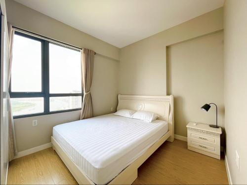 - une chambre avec un lit blanc et une fenêtre dans l'établissement Masteri Thao Dien Apartment, 2BRs, 2WC, Free service, shopping mall, à Hô-Chi-Minh-Ville