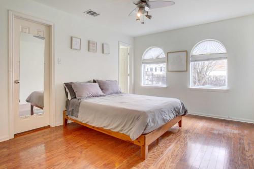 a white bedroom with a bed and two windows at Downtown Houston Townhome with City Views! in Houston