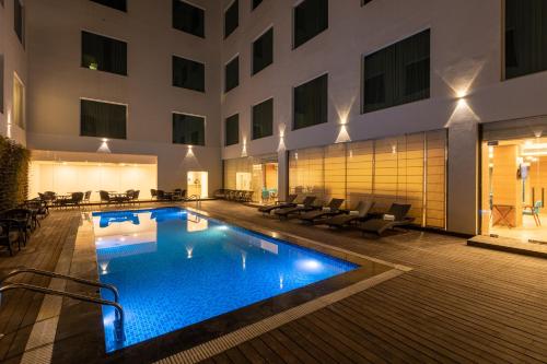 une piscine d'hôtel au milieu d'un bâtiment dans l'établissement ExpoInn Suites and Convention, à Greater Noida
