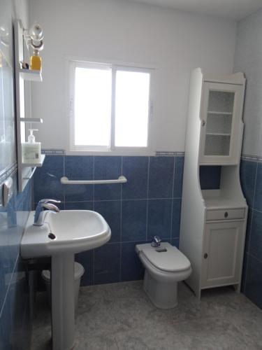 La salle de bains est pourvue d'un lavabo, de toilettes et d'une fenêtre. dans l'établissement B&B Casa Sarandy, à Almogía