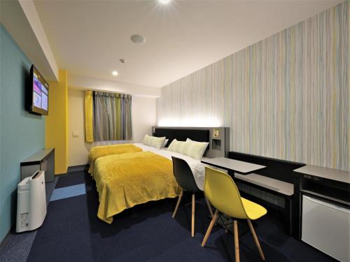 um quarto de hotel com uma cama, uma mesa e cadeiras em Green Rich Hotel Okinawa Nago (Artificial hot spring Futamata Yunohana) em Nago