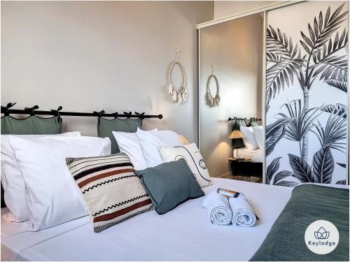 1 dormitorio con cama blanca y espejo grande en Leu Bengali - 3 étoiles - T4 duplex à Saint-Leu en Saint-Leu