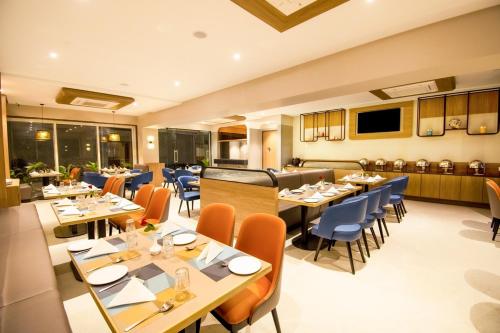 een restaurant met tafels en stoelen in een kamer bij Meritas Aura Resort in Lonavala